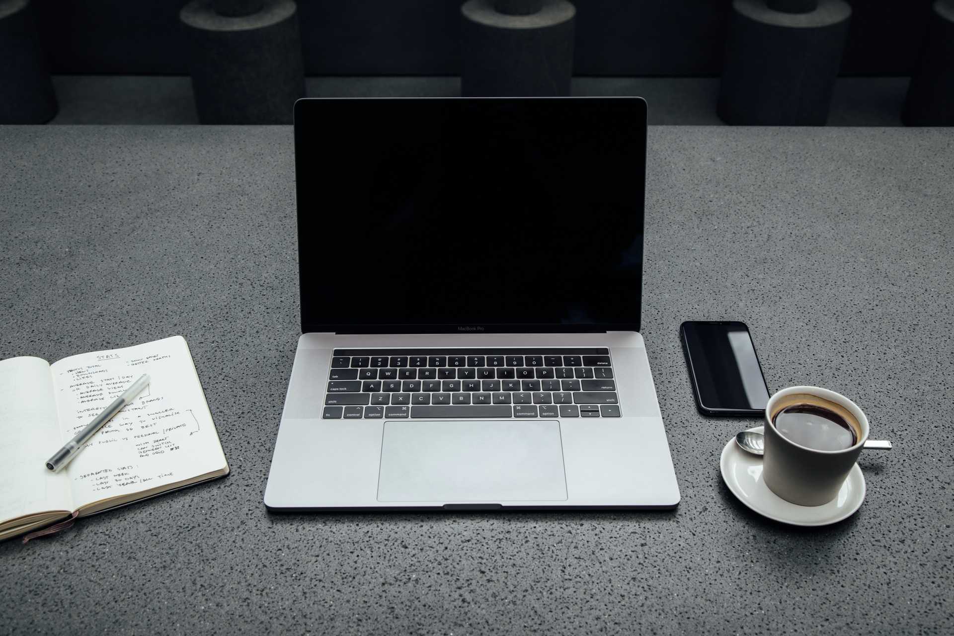 A laptop, a desk and a cup of coffee