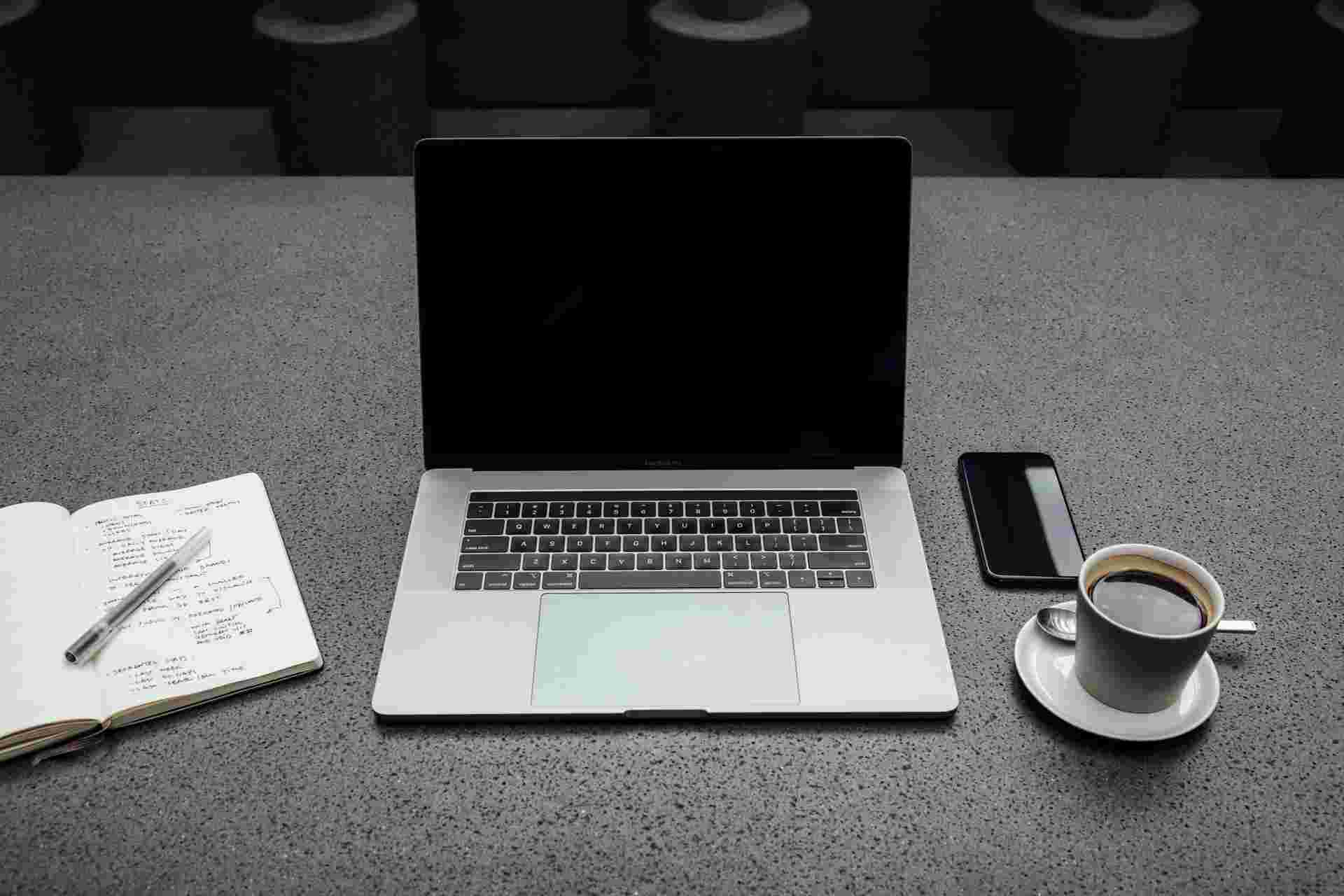 A laptop, a desk and a cup of coffee